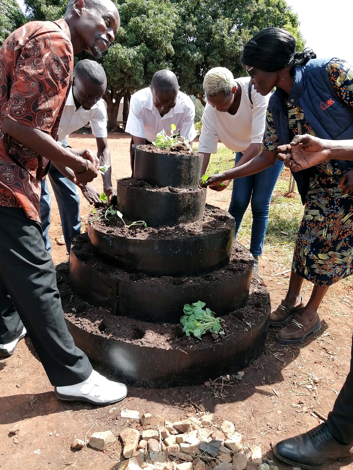 SUCSA staff and community members building a tyre tower garden