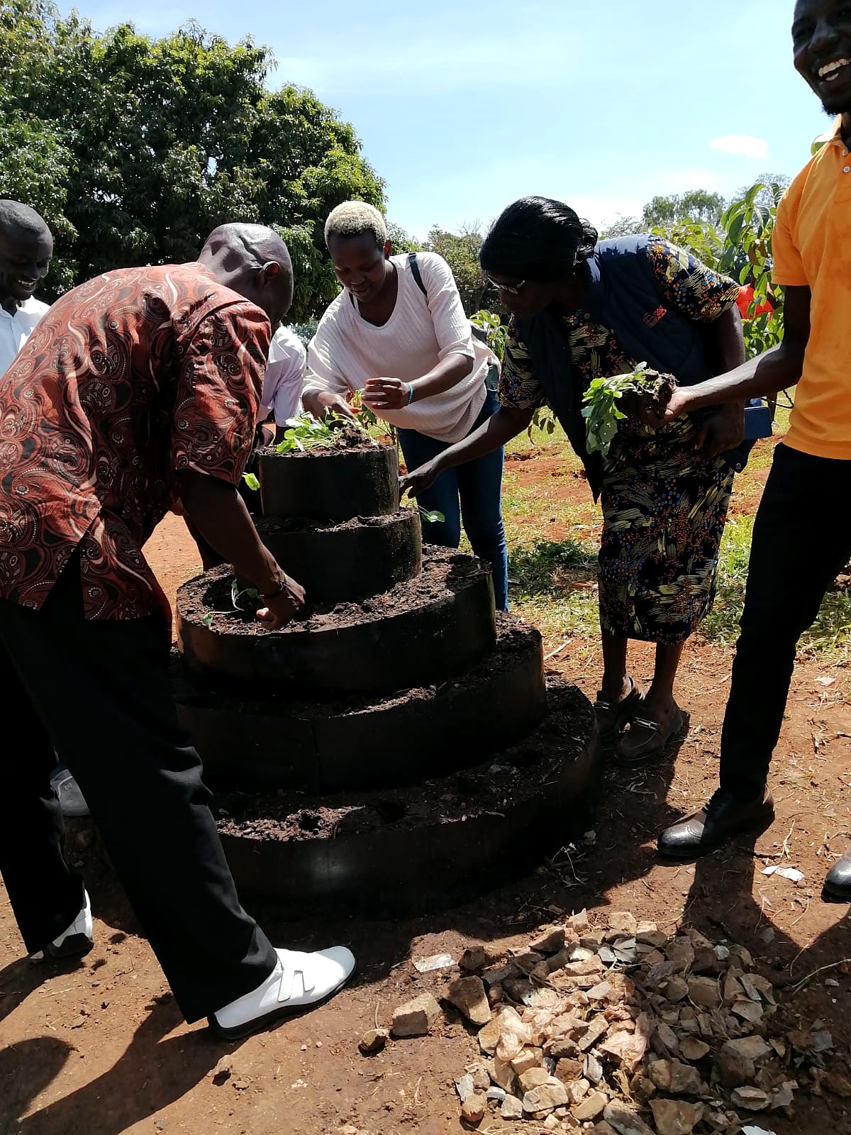 A community member tending vegetables in a tyre tower garden